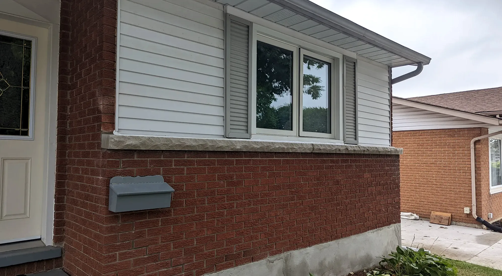 Freshly parged foundation along the brick wall of a Cambridge home