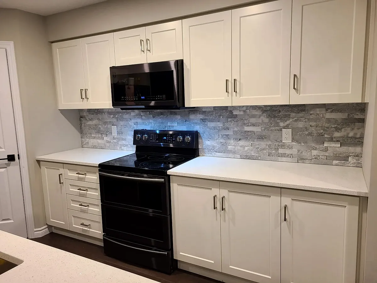 Stacked stone backsplash in a white kitchen