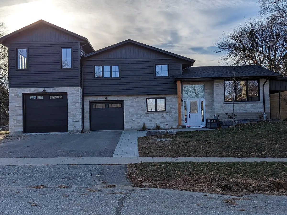 Two storey home with stone veneer front and new concrete driveway