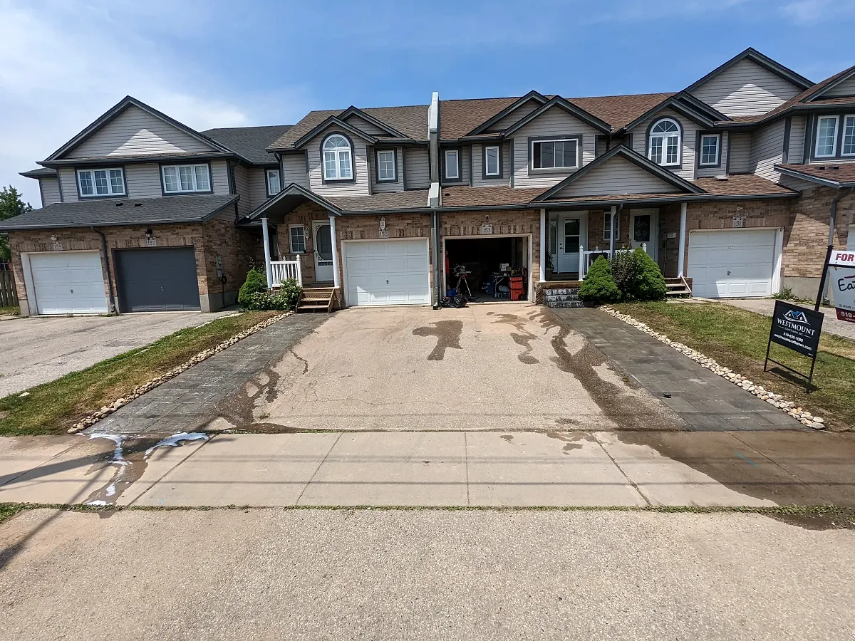 Freshly poured wide concrete driveway in front of townhomes