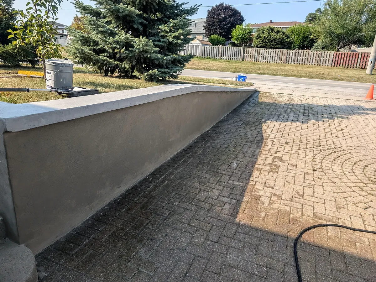 Smooth parged foundation wall alongside a driveway