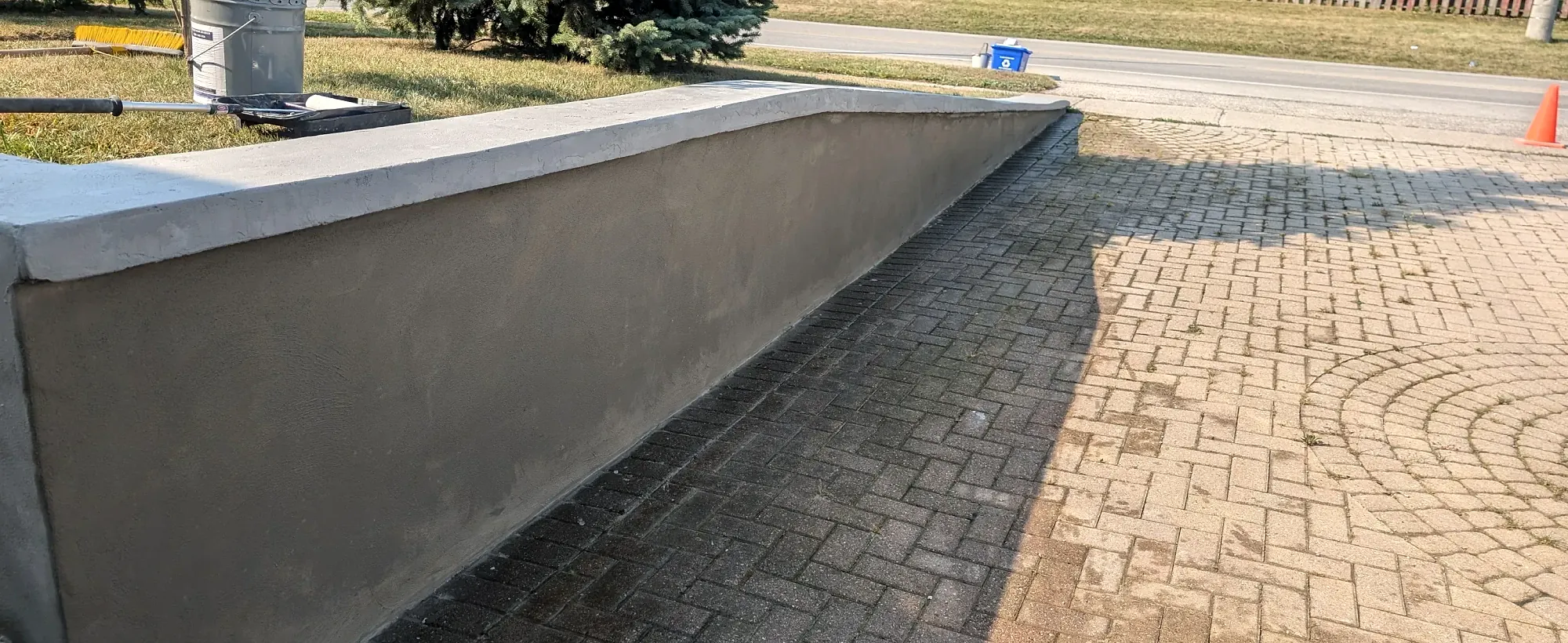 Smooth parged foundation wall alongside a driveway