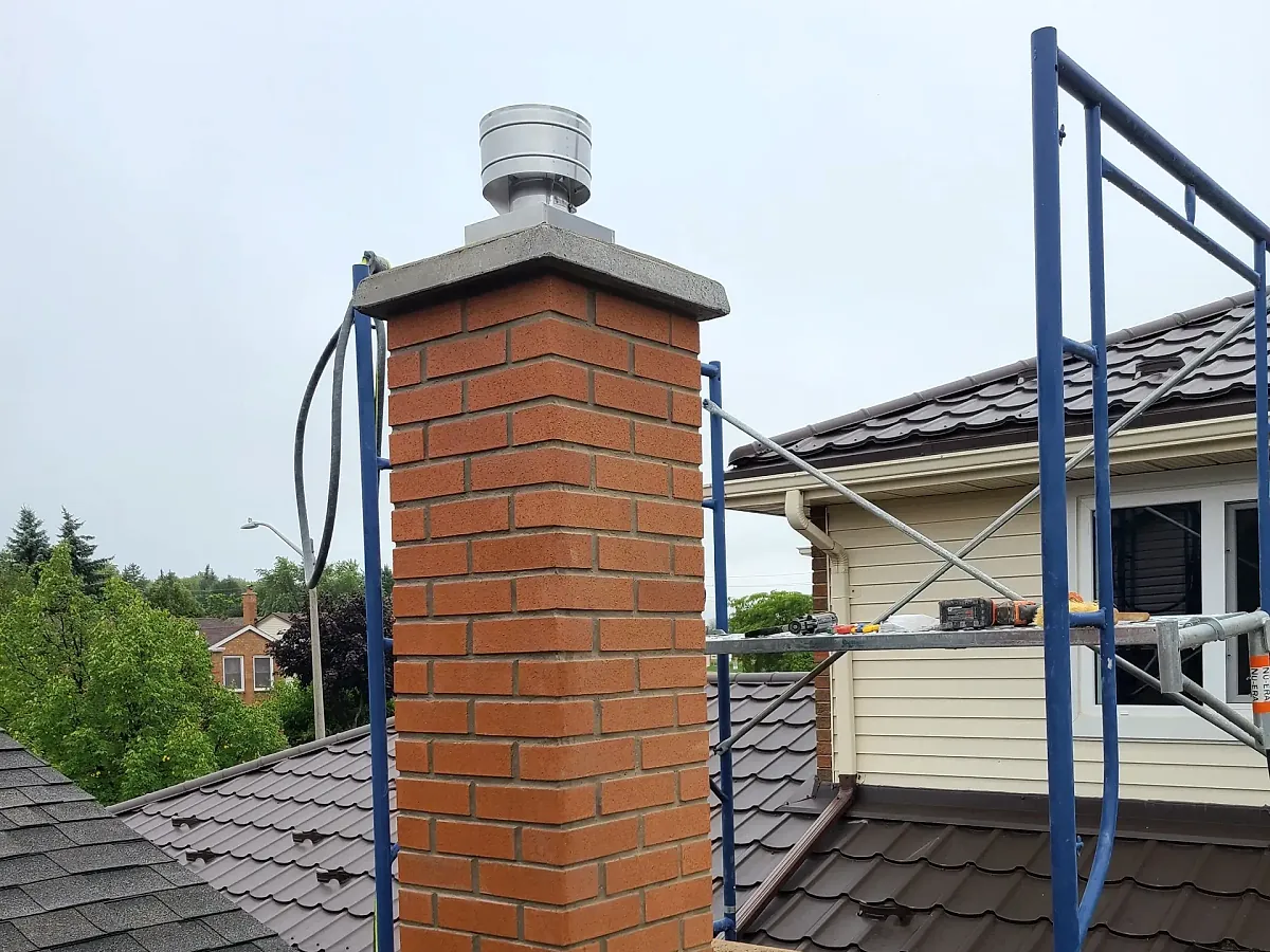 Repointed red brick chimney with fresh mortar joints