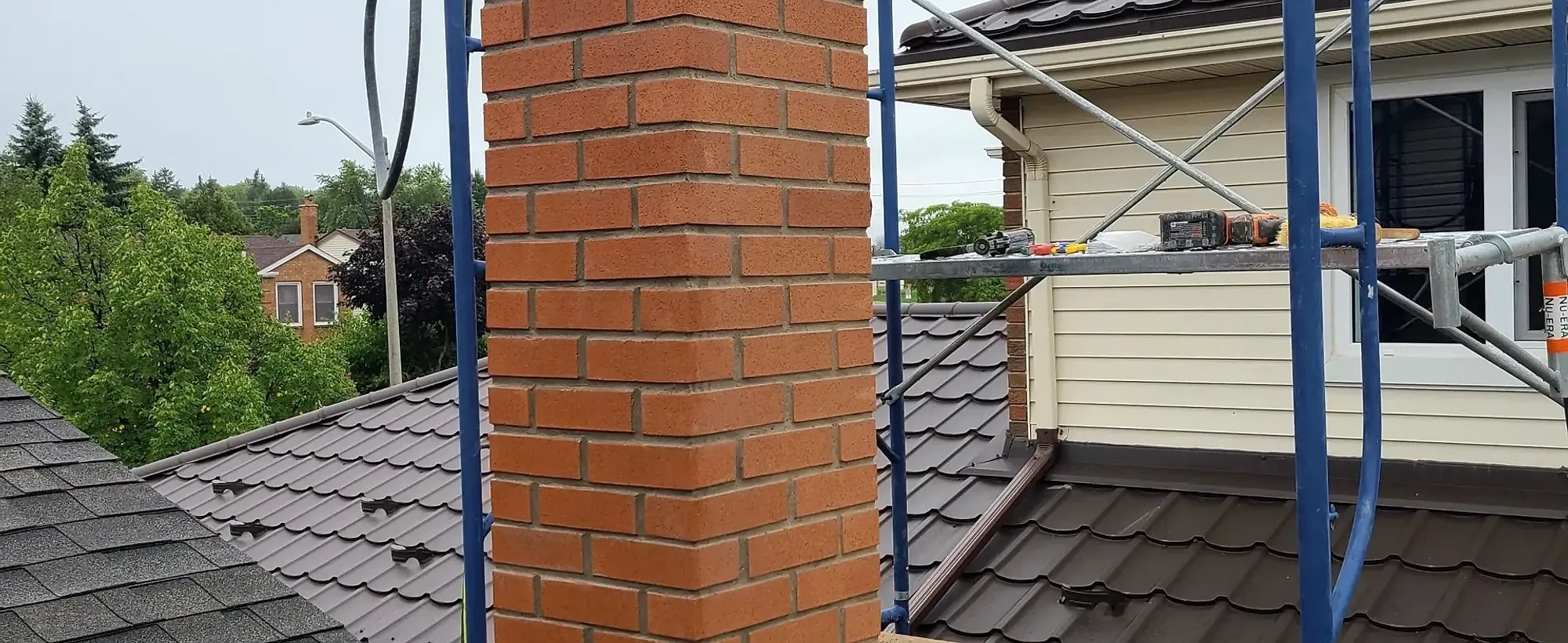 Repointed red brick chimney with fresh mortar joints